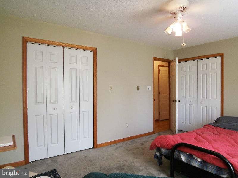 667 Morgan Grove Road Shepherdstown, WV 25443 - Photo 27 of 30 a bedroom with a bed and a chandelier