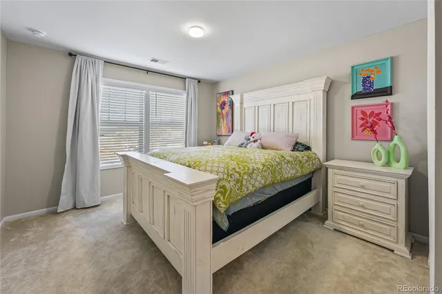 a bed sitting in a bedroom next to a window