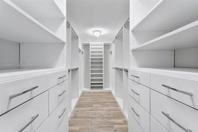 a hallway with white cabinets and stairs