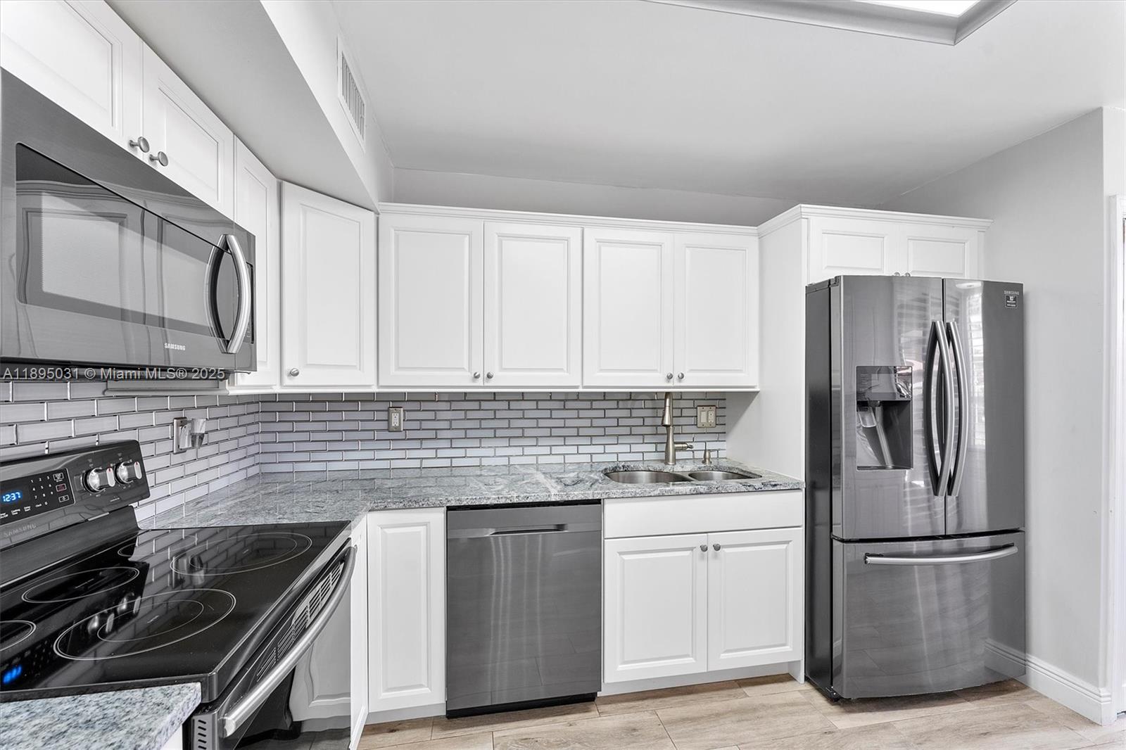 7225 Promenade Drive, Unit 102 Boca Raton, FL 33433 - Photo 5 of 18 a kitchen with a stove microwave and a refrigerator