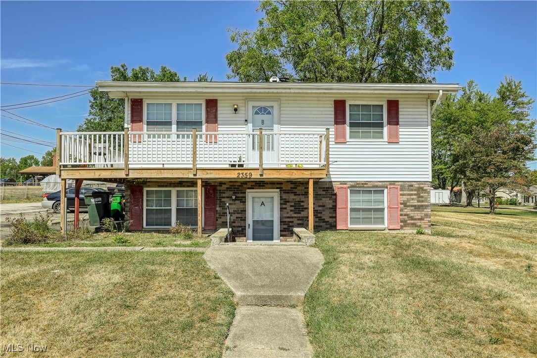 2359 Sanitarium Road Lakemore, OH 44250 - Photo 2 of 29 View of front of property with brick siding, a front yard, and a balcony