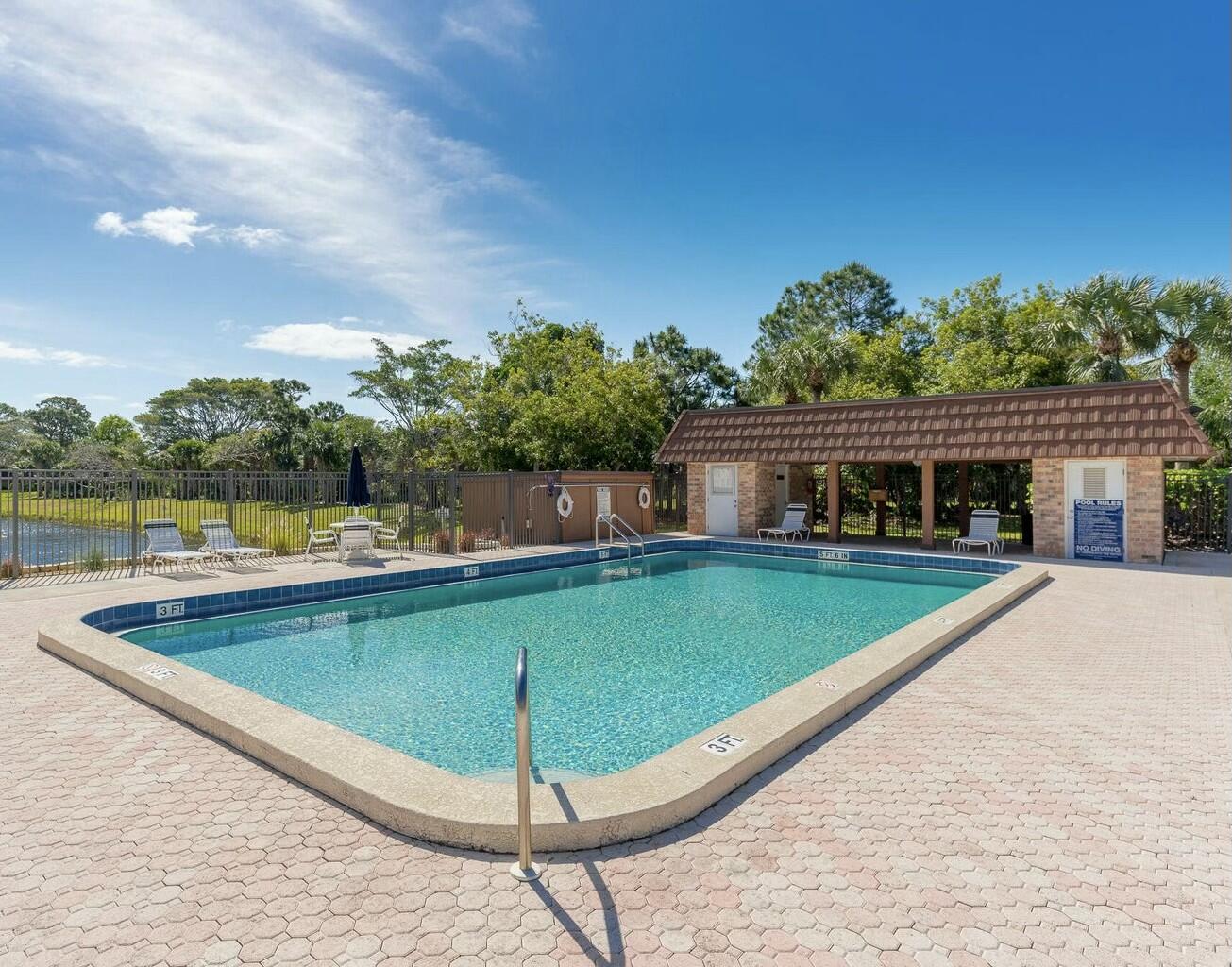 6038 Southeast Riverboat Drive, Unit 716 Stuart, FL 34997 - Photo 21 of 28 a view of a swimming pool with a lounge chairs