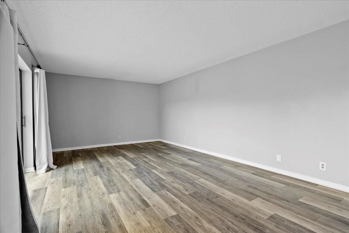 6038 Southeast Riverboat Drive, Unit 716 Stuart, FL 34997 - Photo 3 of 28 a view of an empty room and wooden floor