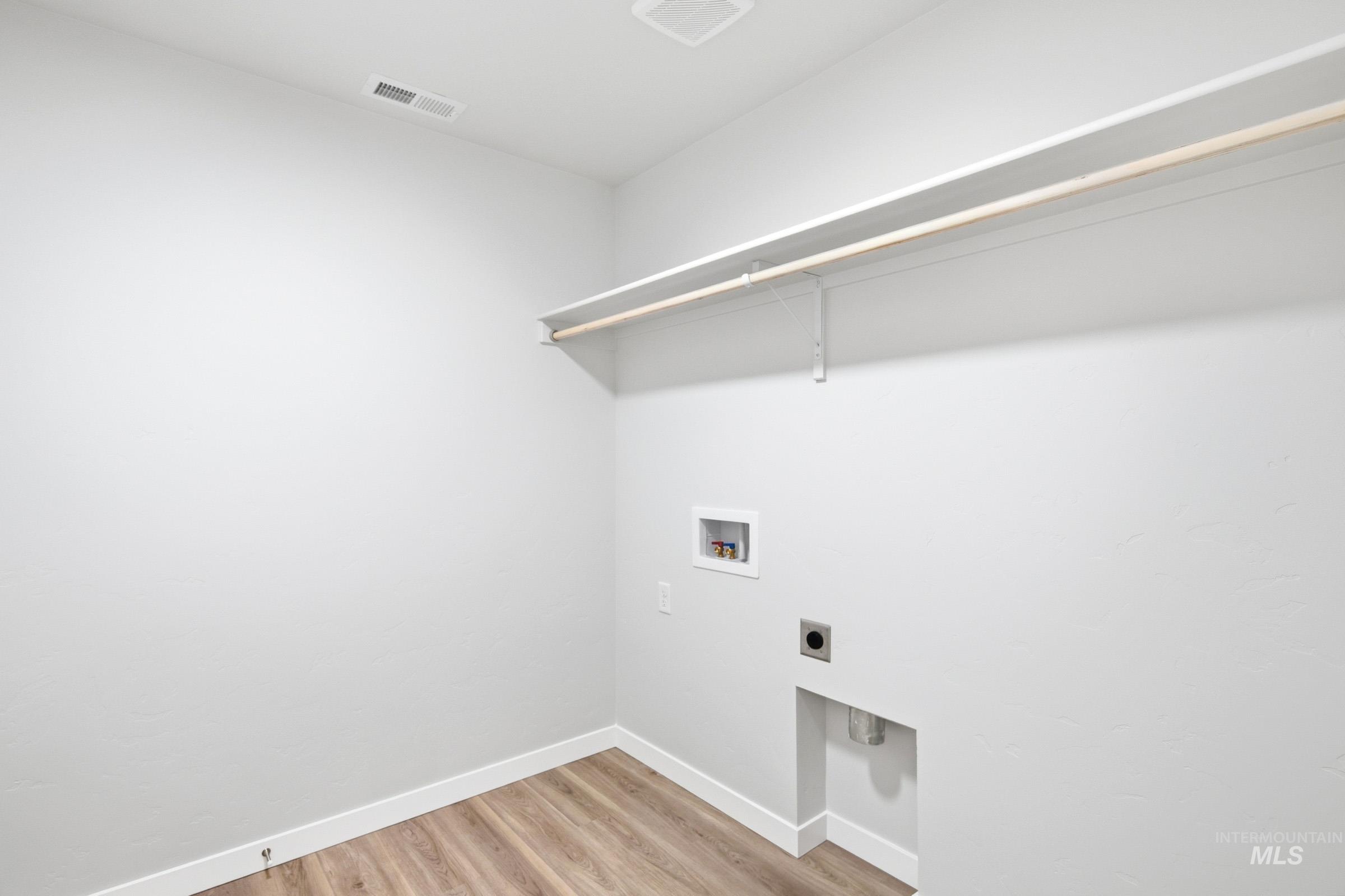 13735 Inman Court Caldwell, ID 83607 - Photo 14 of 20 Laundry room featuring light wood-style floors, electric dryer hookup, and washer hookup
