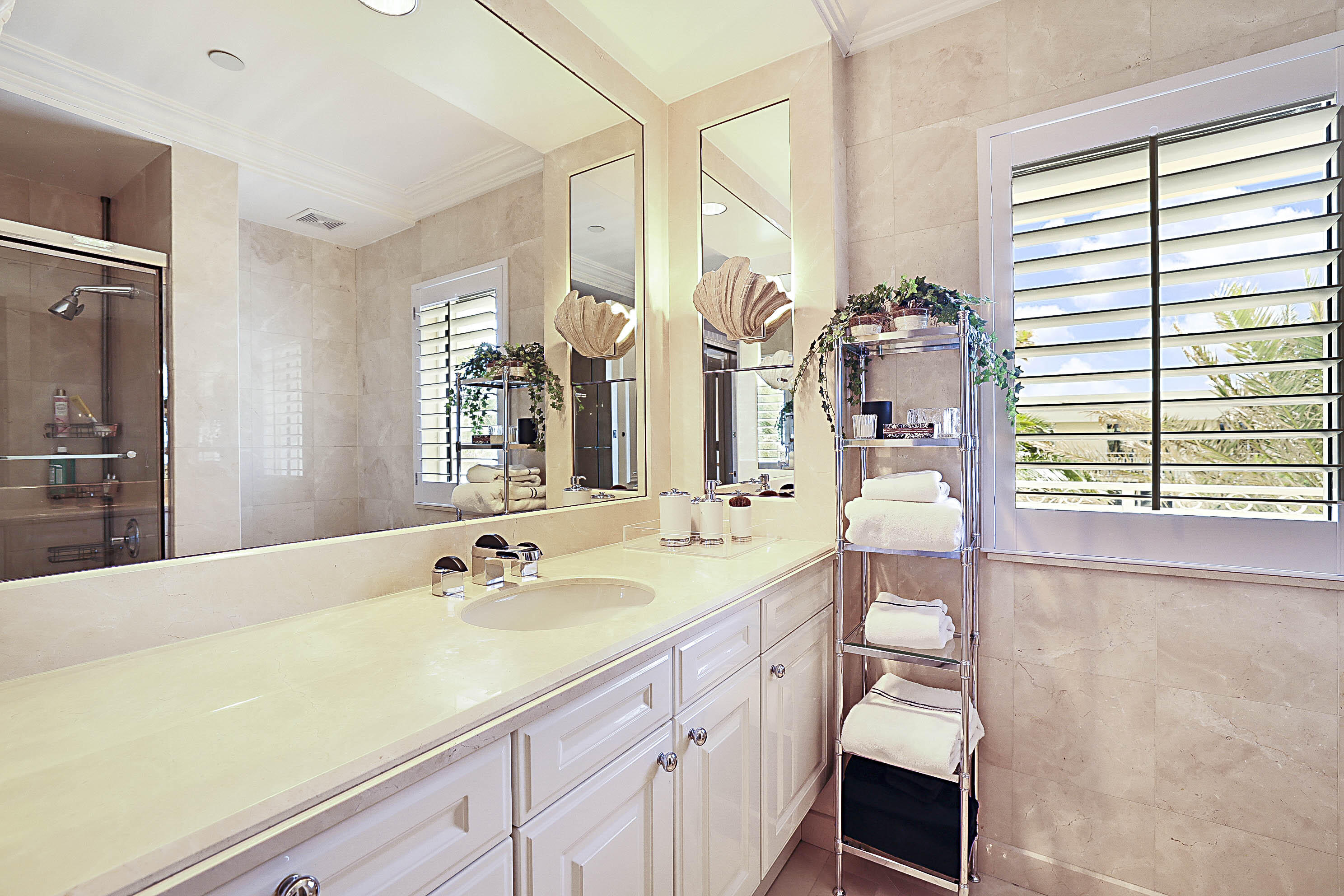19950 South Beach Road, Unit 4 Tequesta, FL 33469 - Photo 14 of 56 a spacious bathroom with a granite countertop sink and a large mirror
