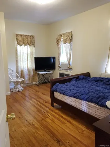a bedroom with a bed window and flat screen tv