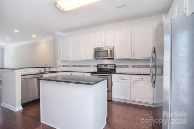 a kitchen with stainless steel appliances granite countertop a sink and a stove