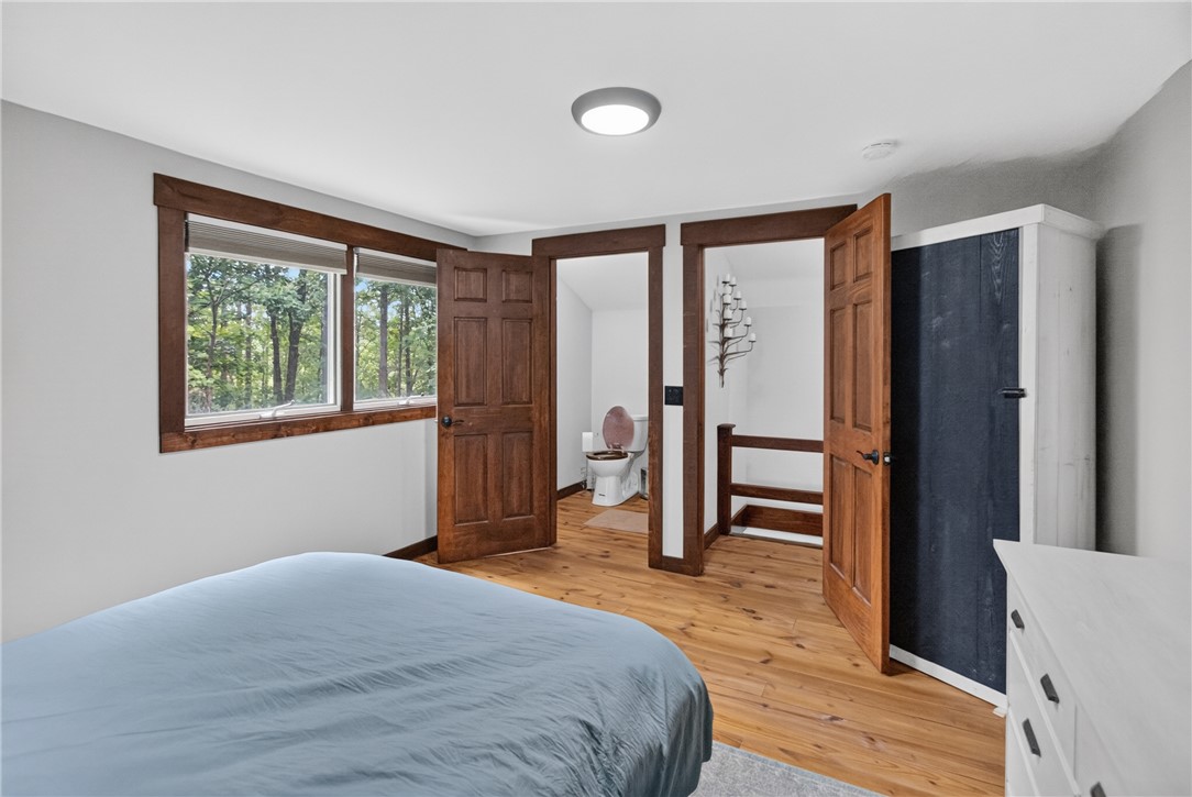 130 Maggie Rufus Lane Westminster, SC 29693 - Photo 24 of 50 Sun-filled bedroom featuring rich wood flooring and trim, offering peaceful views of the surrounding natural landscape.