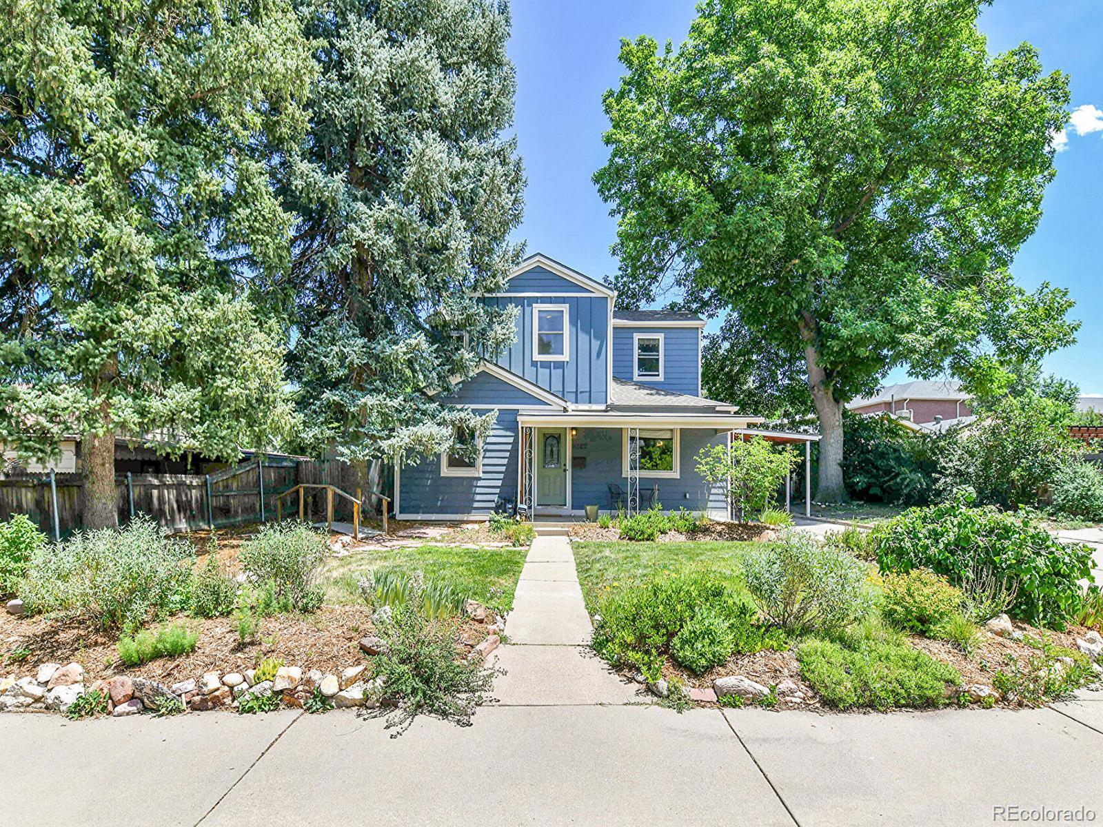 3282 Depew Street Wheat Ridge, CO 80212 - Photo 1 of 50 a front view of a house with a yard and potted plants