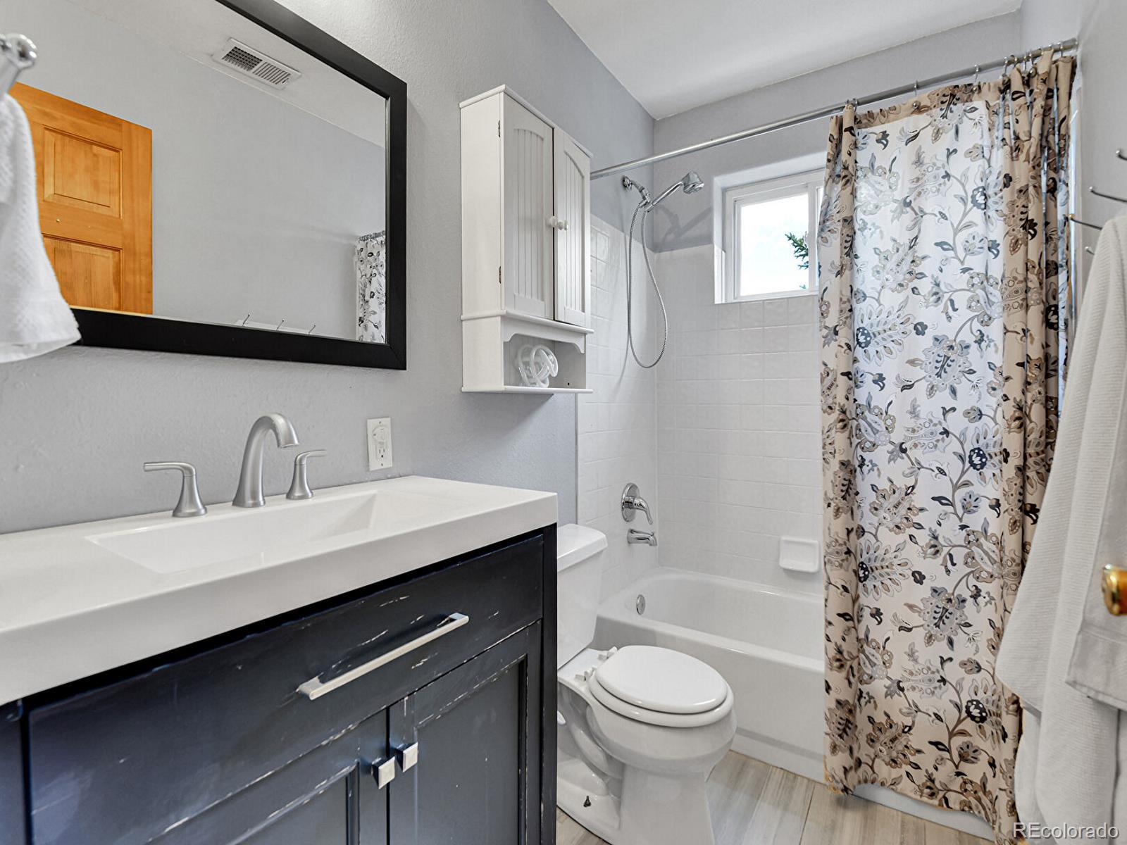 3282 Depew Street Wheat Ridge, CO 80212 - Photo 34 of 50 a bathroom with a sink toilet a mirror and shower
