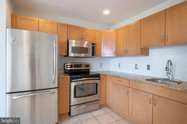 a kitchen with cabinets stainless steel appliances and a sink