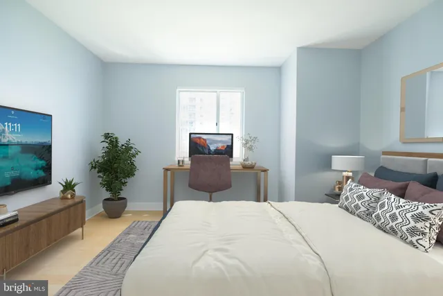 a bedroom with a bed and a potted plant