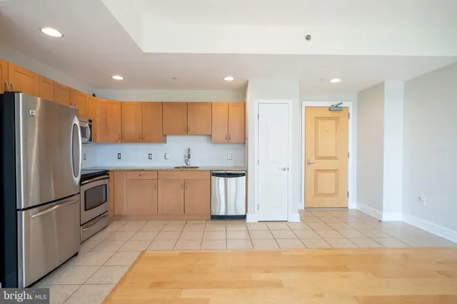 a kitchen with granite countertop a refrigerator and a sink