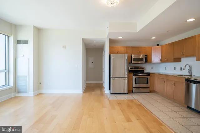 a kitchen with granite countertop a refrigerator stove top oven and sink