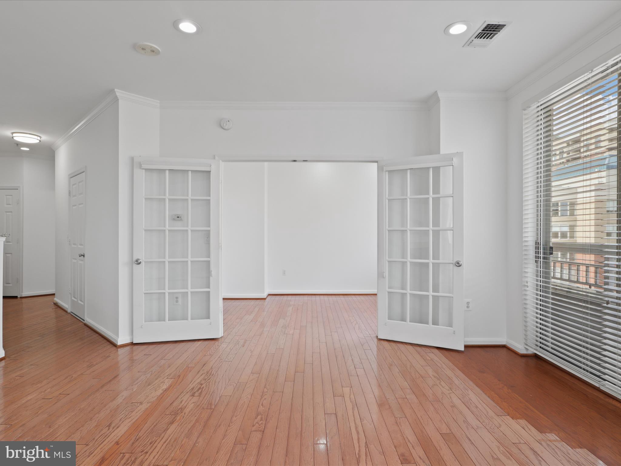 3830 9th Street North, Unit PH3E Arlington, VA 22203 - Photo 13 of 44 an empty room with wooden floor and windows with curtains