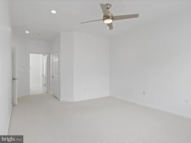 an empty room with a ceiling fan and a window