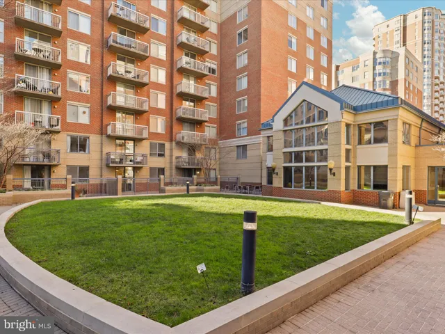 a front view of a building with a garden and plants