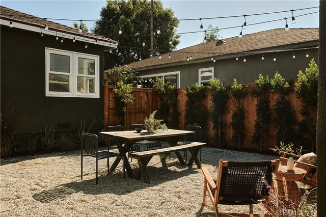 a backyard of a house with table and chairs