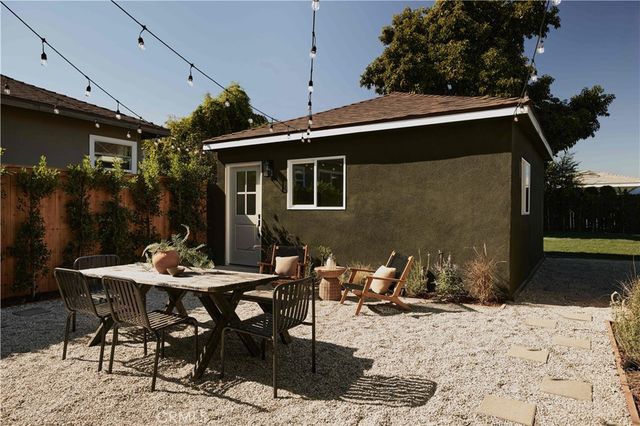 a backyard of a house with table and chairs
