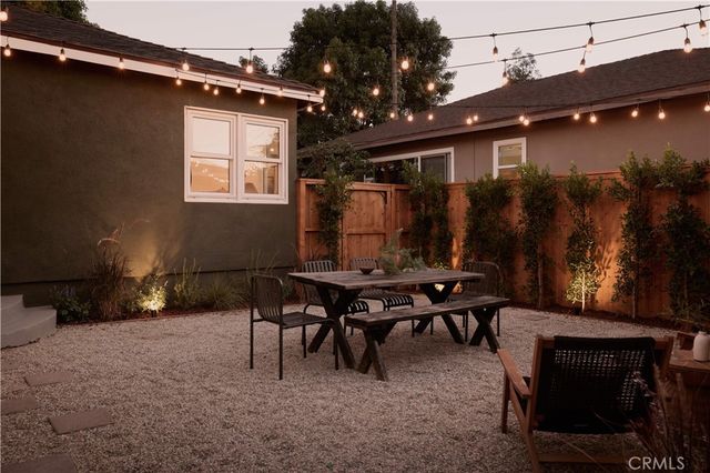a backyard of a house with table and chairs