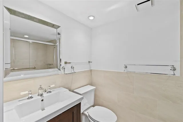 a bathroom with a sink vanity mirror and toilet