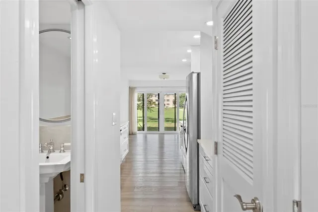 a view of a hallway with bathroom and wooden floor