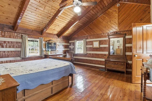 a bedroom with a bed and wooden floor