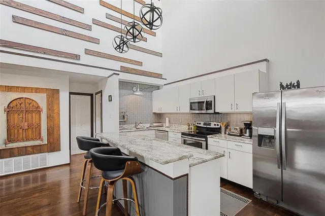 a kitchen with a refrigerator a stove and a sink