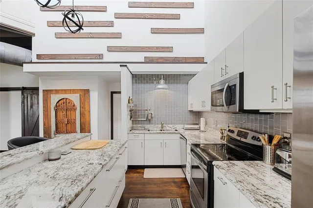 a kitchen with stainless steel appliances kitchen island granite countertop a sink and cabinets
