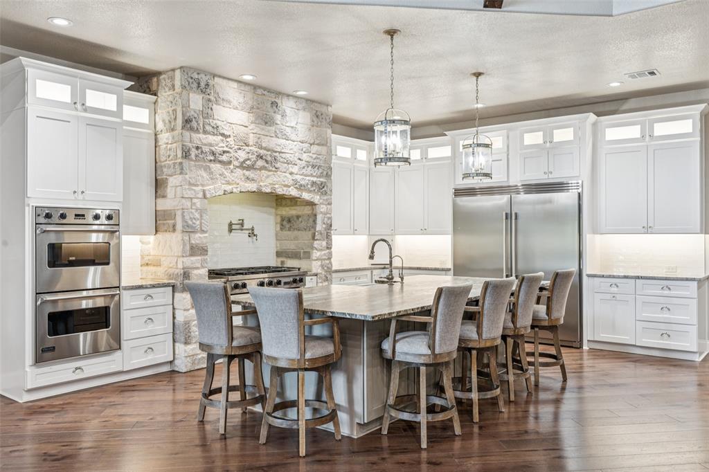 12877 Foutch Road Pilot Point, TX 76258 - Photo 12 of 40 a kitchen with stainless steel appliances kitchen island granite countertop a dining table chairs and granite counter tops