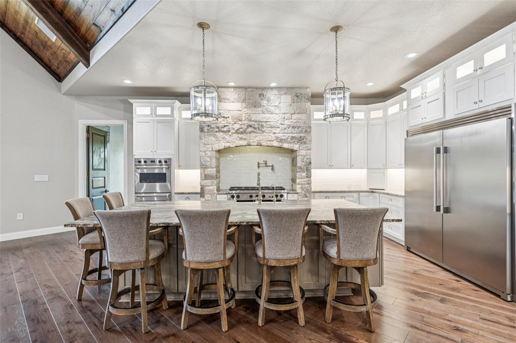 12877 Foutch Road Pilot Point, TX 76258 - Photo 18 of 40 a view of a dining room with furniture a chandelier and wooden floor