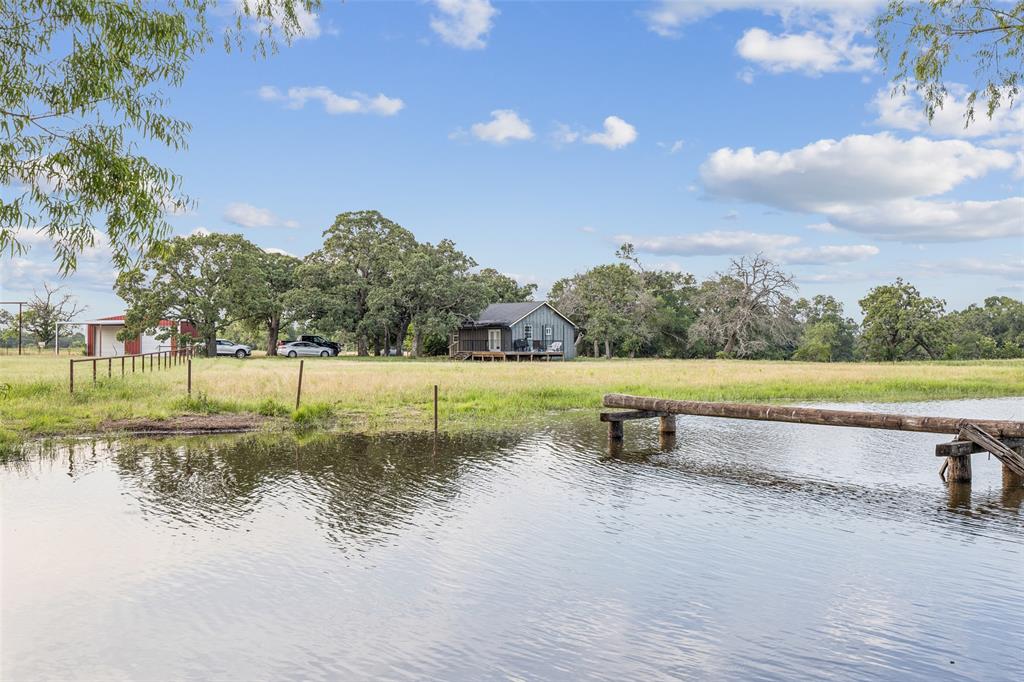 12877 Foutch Road Pilot Point, TX 76258 - Photo 38 of 40 a view of a lake with a yard and a large tree