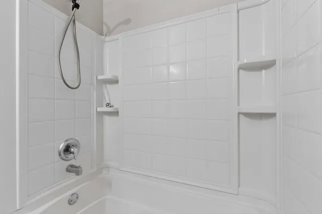 a bathroom with a bath tub with a shower