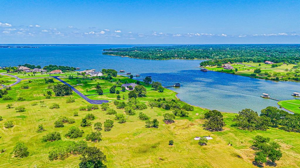 L77 R Moonlight Bay Court Streetman, TX 75859 - Photo 24 of 30 a view of a lake with a building in the background