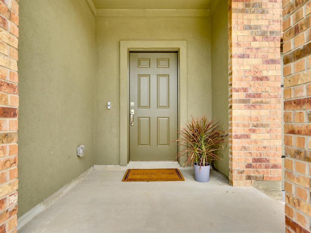 1208 Sweetspire Street Leander, TX 78641 - Photo 36 of 36 Entryway featuring a panel door with trim, stucco siding, and a brick column