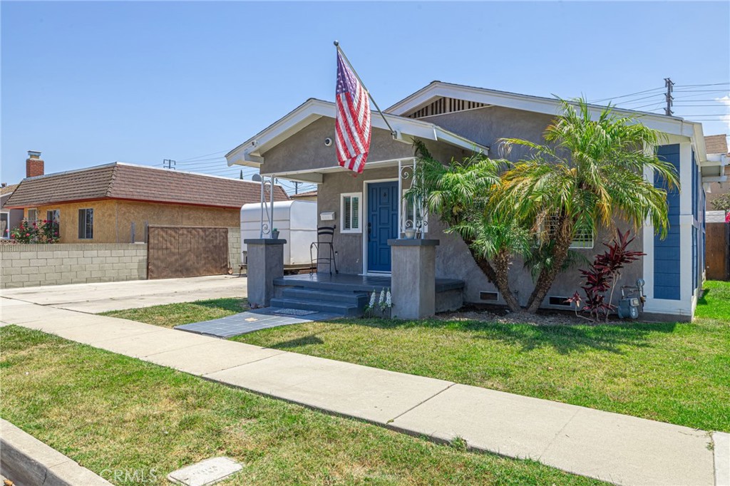 2548 East Washington Street Carson, CA 90810 - Photo 3 of 44 a front view of a house with a yard and potted plants