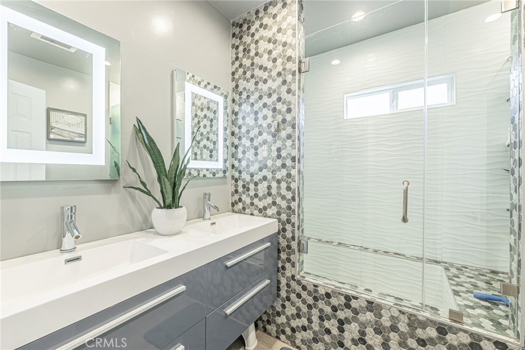 2548 East Washington Street Carson, CA 90810 - Photo 32 of 44 a bathroom with a sink a mirror and shower