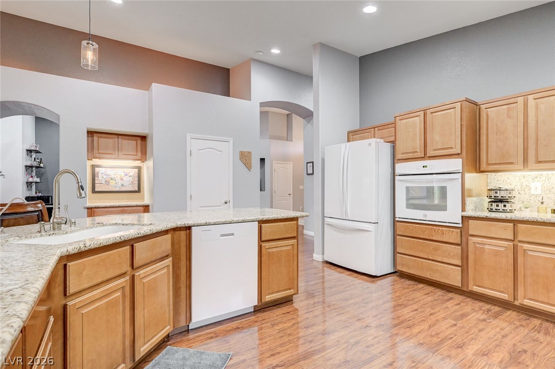 1604 Cattle Ranch Place Henderson, NV 89002 - Photo 23 of 99 An inviting kitchen features a central island with a sink and gleaming hardwood floors.