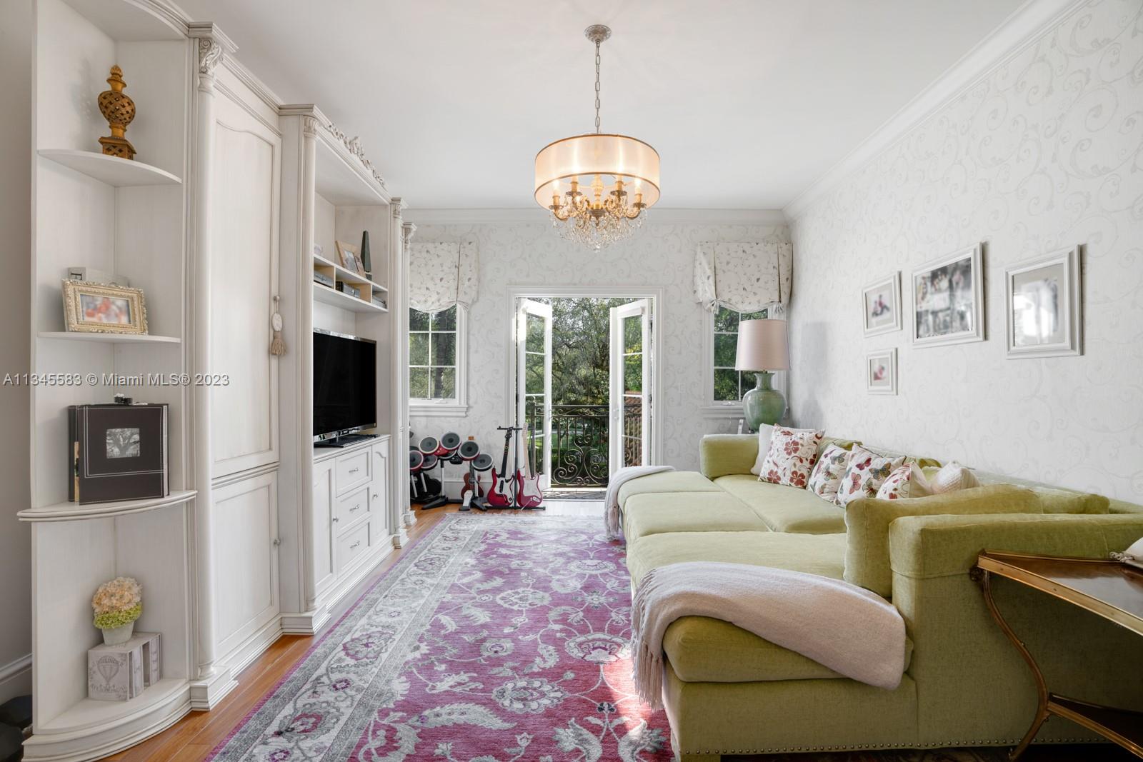 5001 Pine Drive Miami, FL 33143 - Photo 17 of 32 a living room with furniture a flat screen tv and a floor to ceiling window