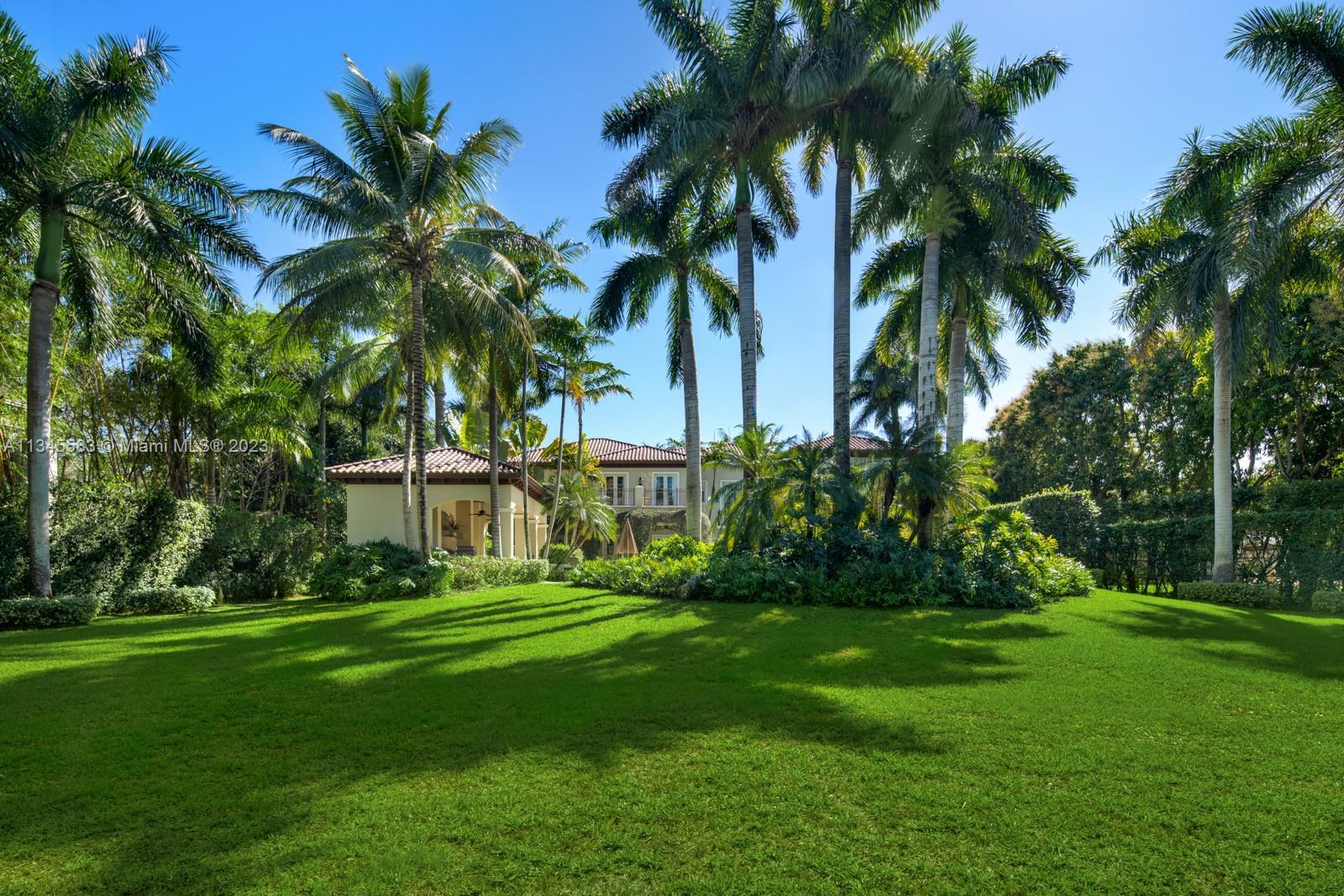 5001 Pine Drive Miami, FL 33143 - Photo 26 of 32 a view of a white house with a big yard and palm trees