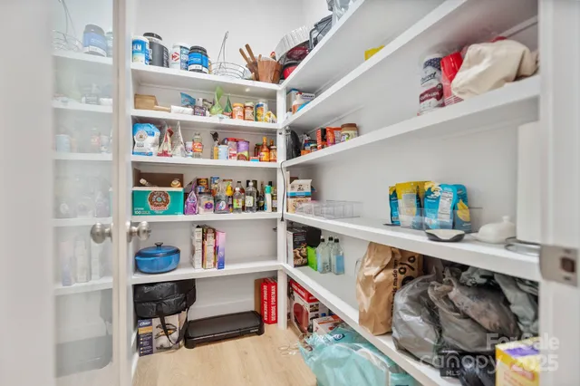 a utility room with stainless steel appliances lots of clutter and baby