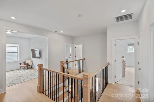a view of a hallway with bedroom and windows