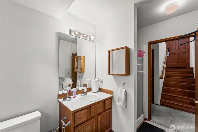 a bathroom with a sink toilet and mirror