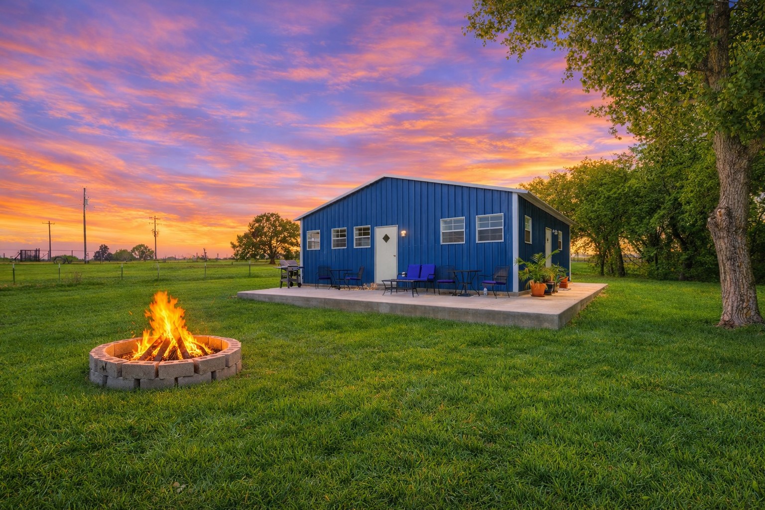 224 Old Coach Lane Elgin, TX 78621 - Photo 4 of 25 The property features a vibrant blue exterior, a spacious green lawn, and a stone fire pit