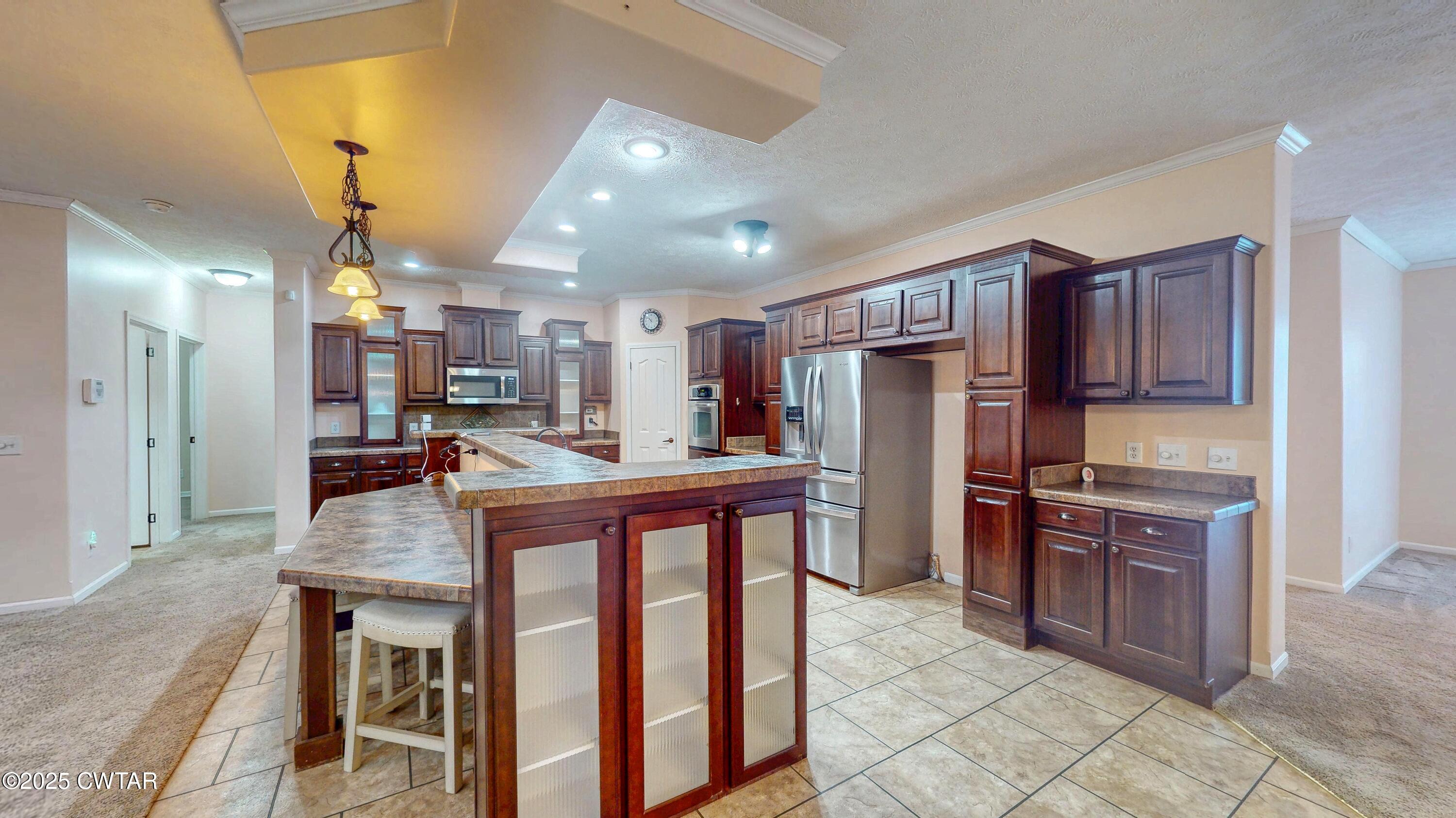 555 Brandon Road Huntingdon, TN 38344 - Photo 12 of 41 a kitchen with stainless steel appliances granite countertop a table chairs sink refrigerator and cabinets