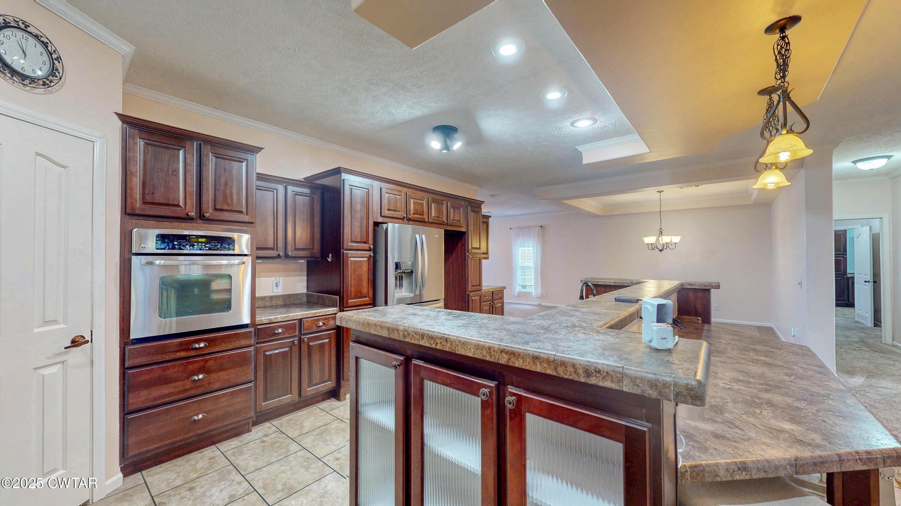 555 Brandon Road Huntingdon, TN 38344 - Photo 13 of 41 a kitchen with kitchen island granite countertop wooden cabinets and a refrigerator