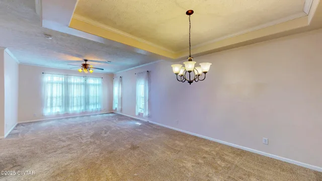 a view of a livingroom with a chandelier furniture and windows