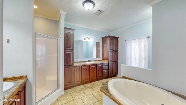 a spacious bathroom with a tub sink and mirror
