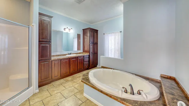 a bathroom with a tub a sink and a mirror