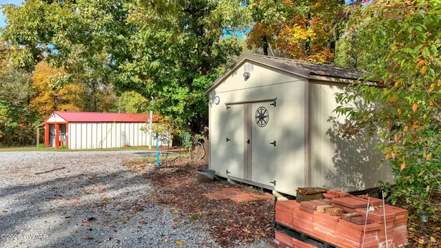 a backyard of a house with a tree and wooden fence